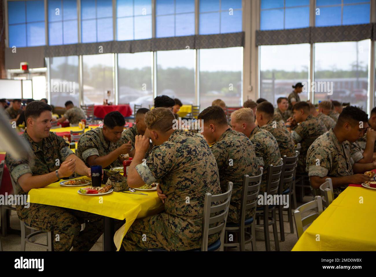 U.S. Marines eat during the Mess Hall-303 re-opening ceremony on Marine Corps Base (MCB) Camp Lejeune, North Carolina, July 12, 2022. Mess Hall-303 provides support to MCB Camp Lejeune by providing meals with responsive service by a well-trained workforce. Stock Photo