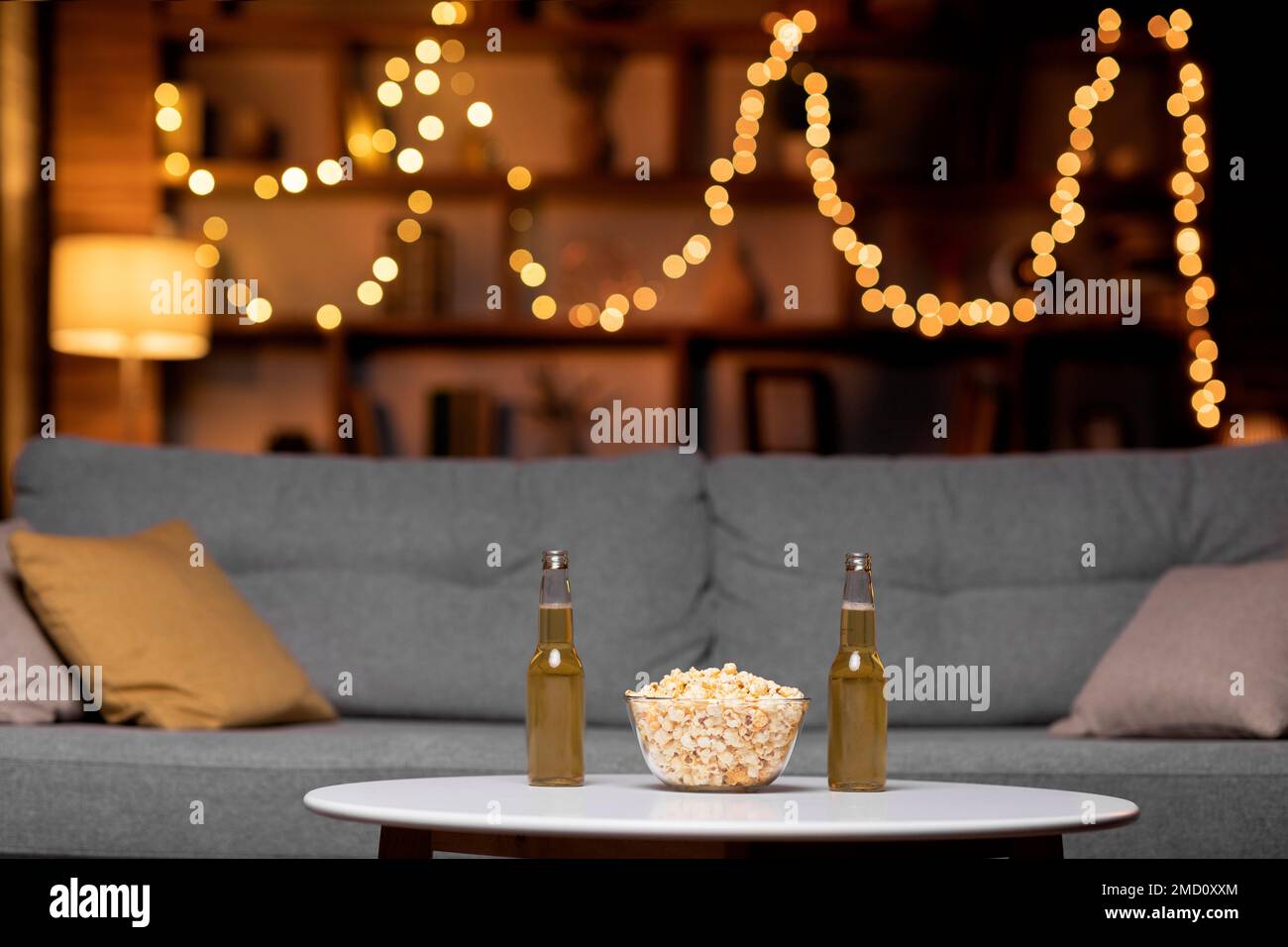 Glass bowl of popcorn and two bottles of beer Stock Photo