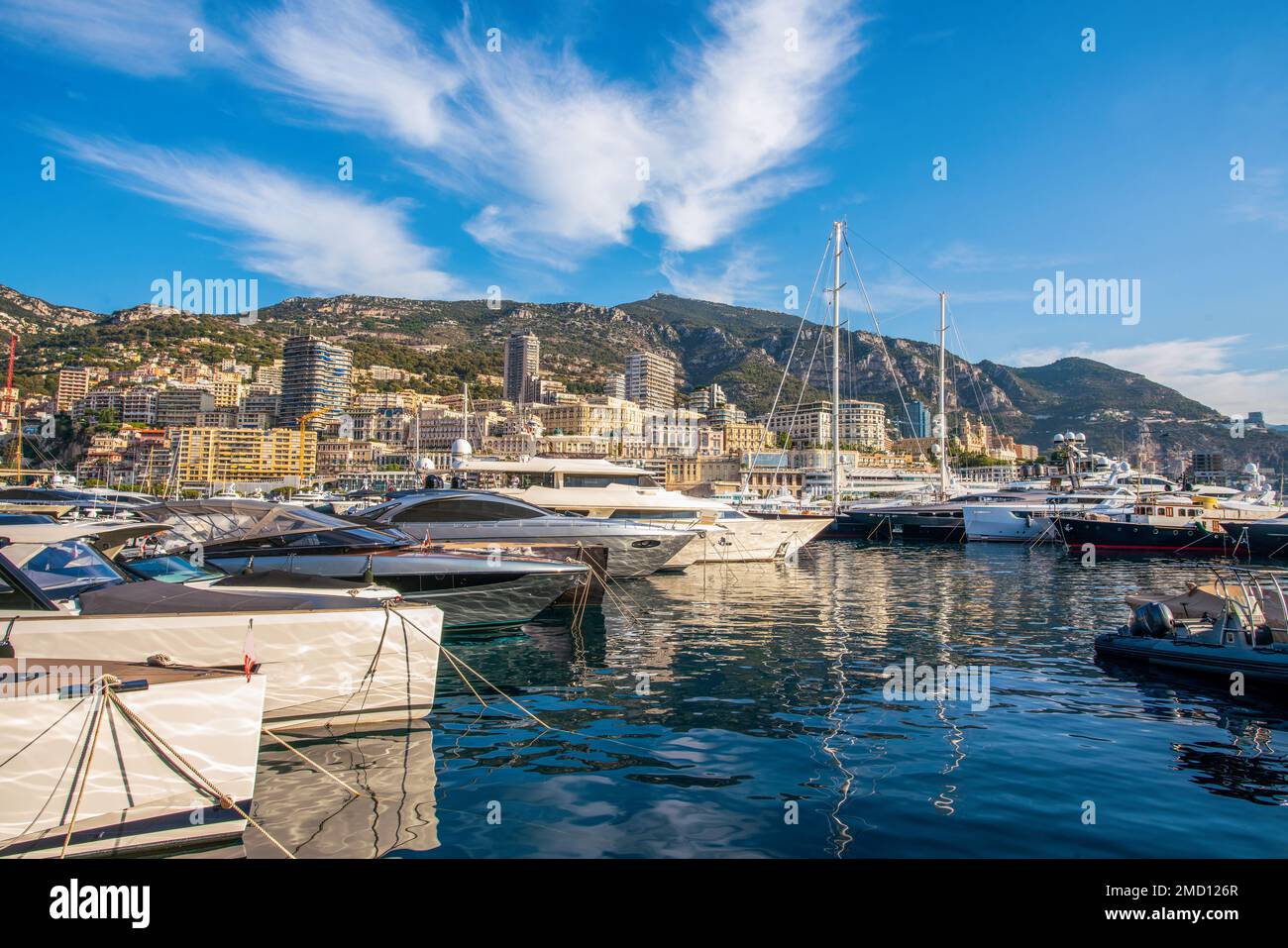Idyllic view of the harbor (Port Hercule) of Monaco with luxury yachts and the skyline of Monaco in the background - also famous old  building 'Monte Stock Photo
