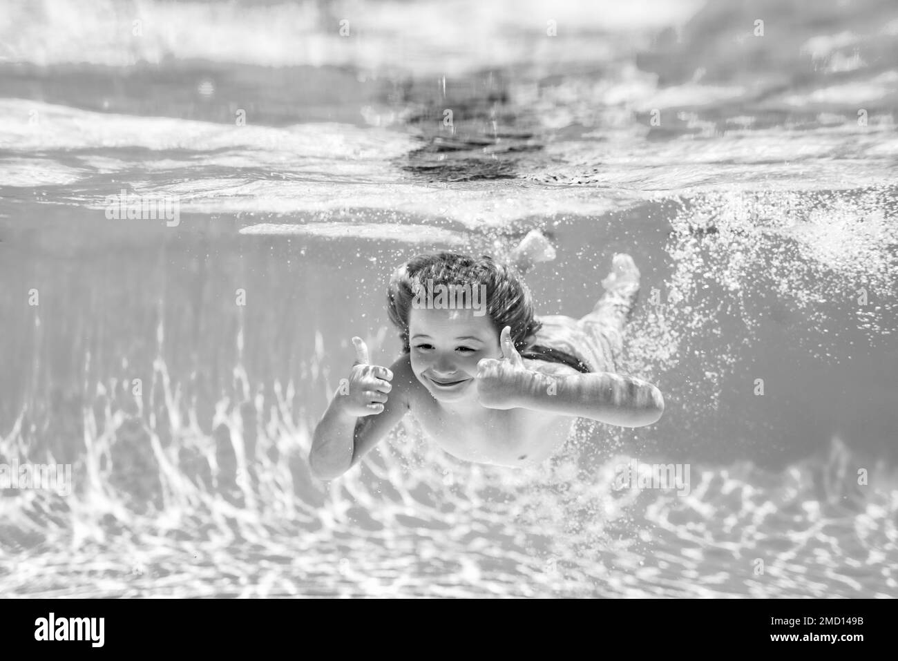 Underwater child swims in pool, healthy child swimming and having fun