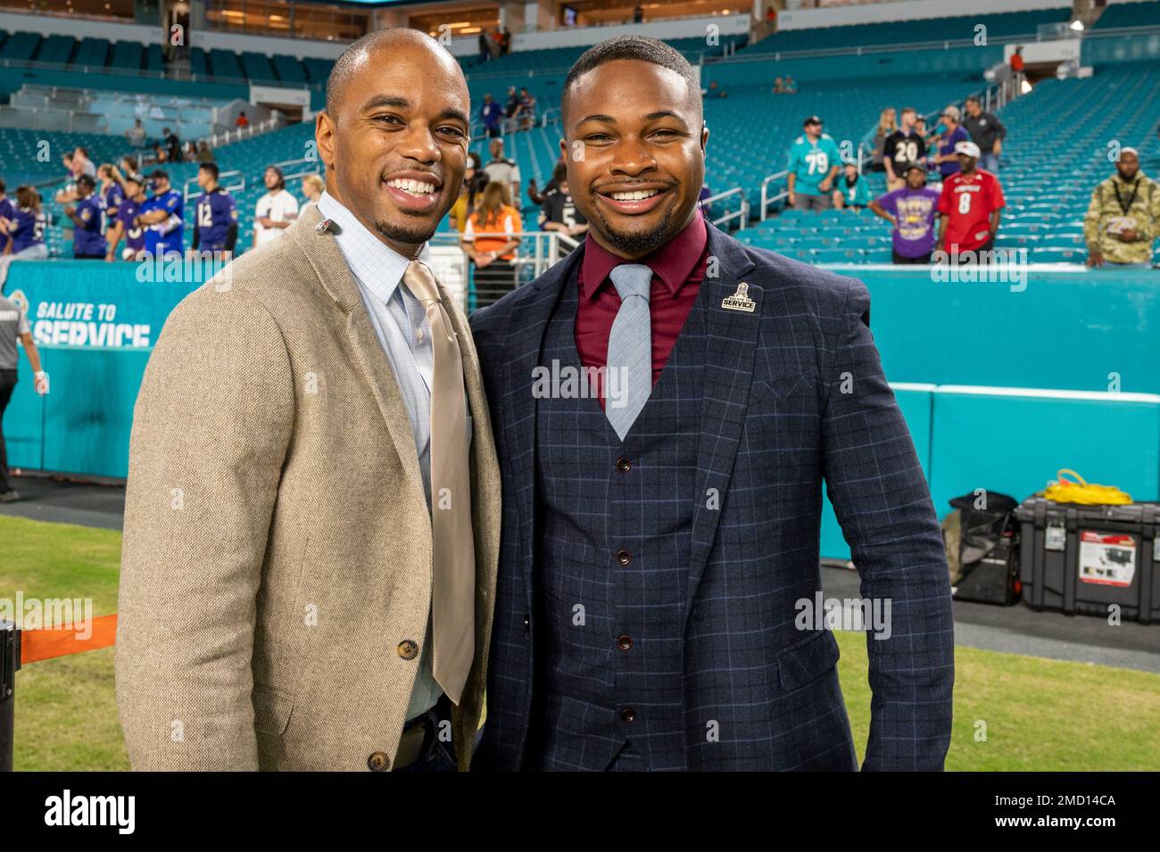 ESPN broadcast journalist Coley Harvey (left) and NFL Network reporter  Cameron Wolfe pose on the sidelines before the start of an NFL football  game between the Baltimore Ravens and the Miami Dolphins