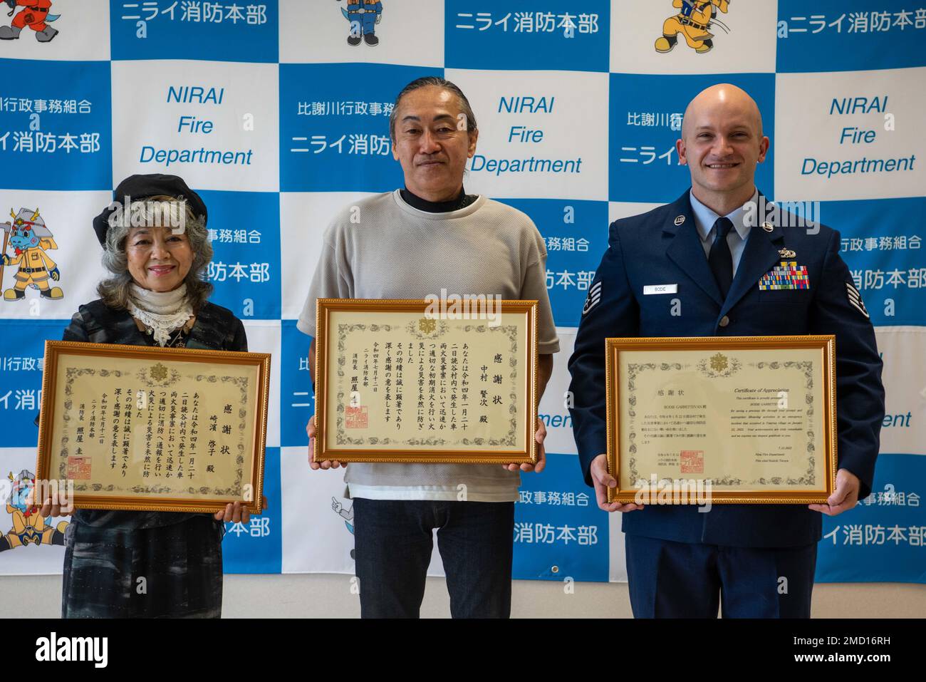 U.S. Air Force Staff Sgt. Garrett Bodie, right, 733rd Air Mobility Squadron support NCO in charge, holds his certificate of appreciation while standing alongside two Japanese locals at a ceremony meant to honor the three of them, at the Nirai Fire Department in Okinawa, Japan, July 12. All three honorees received recognition for helping save the life of a local man whose truck caught fire on Jan. 22, 2022. Stock Photo