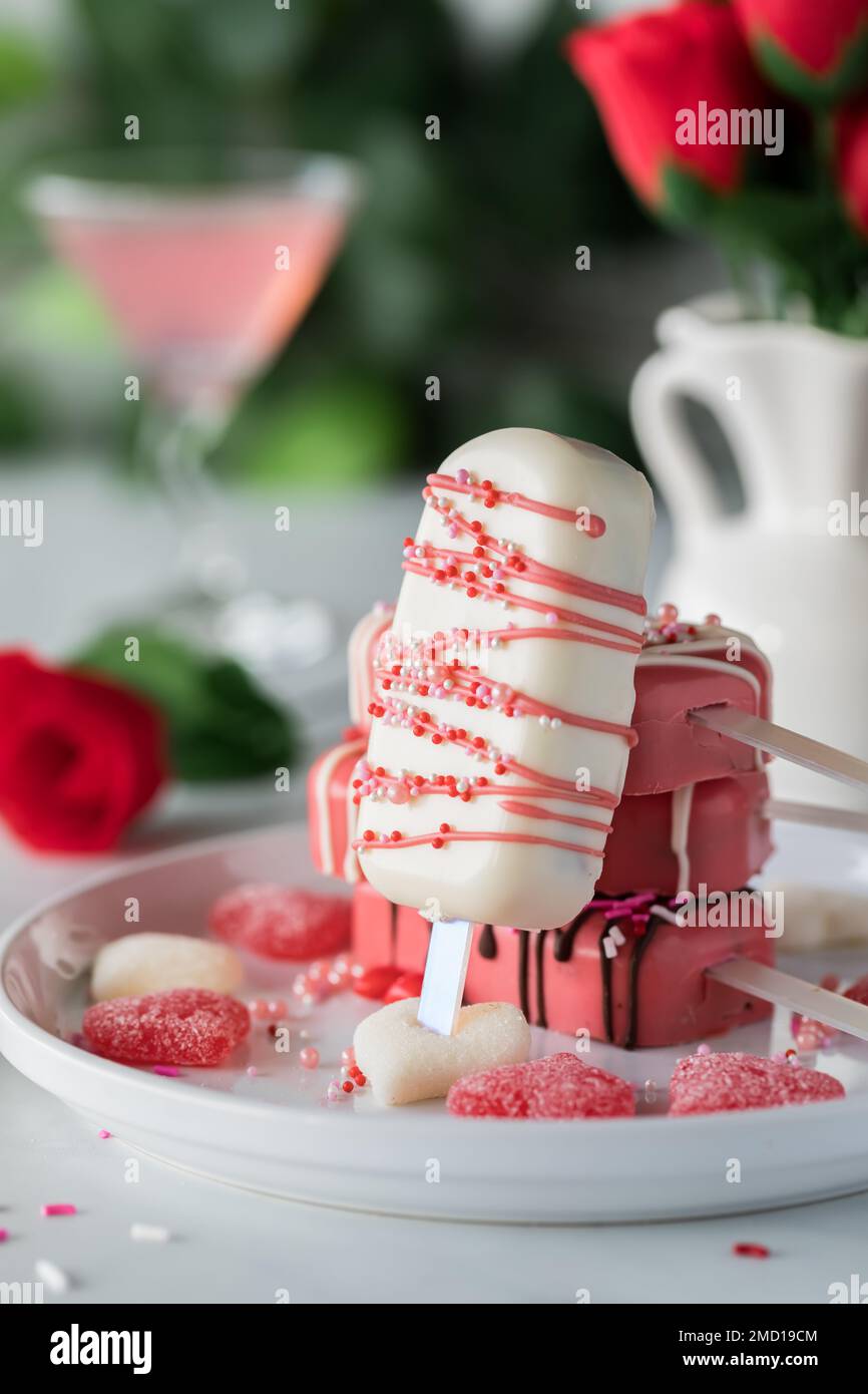 A homemade Valentine cakesicle leaning against a pile of other cakesicles. Stock Photo