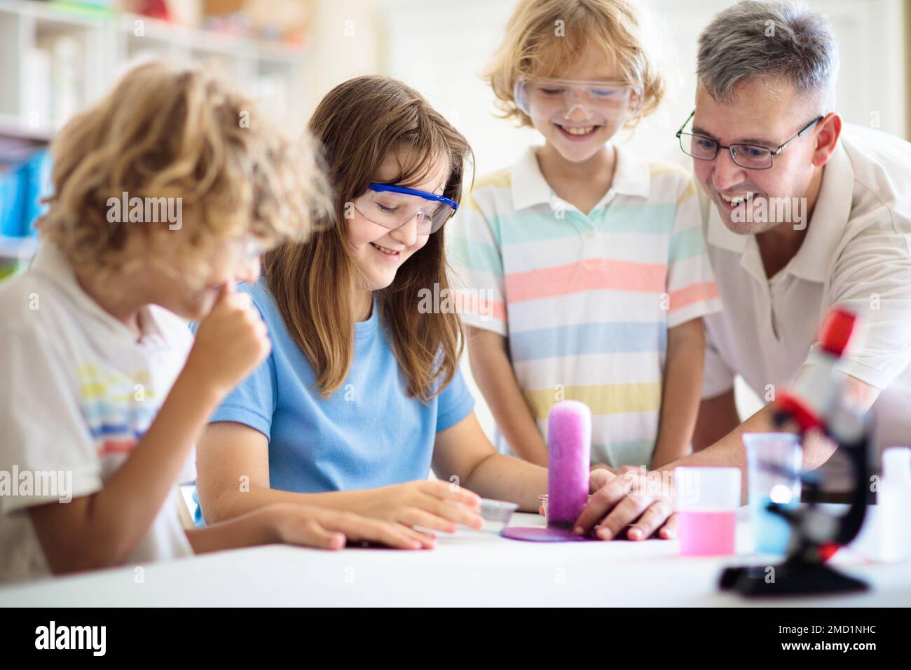 School science class. Students at chemistry lesson. Kids watch chemical reaction. Teacher and