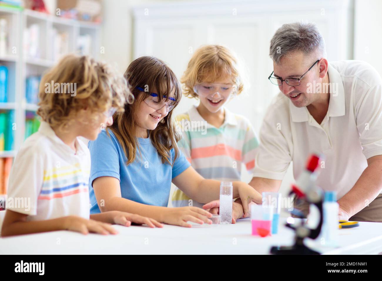 School science class. Students at chemistry lesson. Kids watch chemical reaction. Teacher and