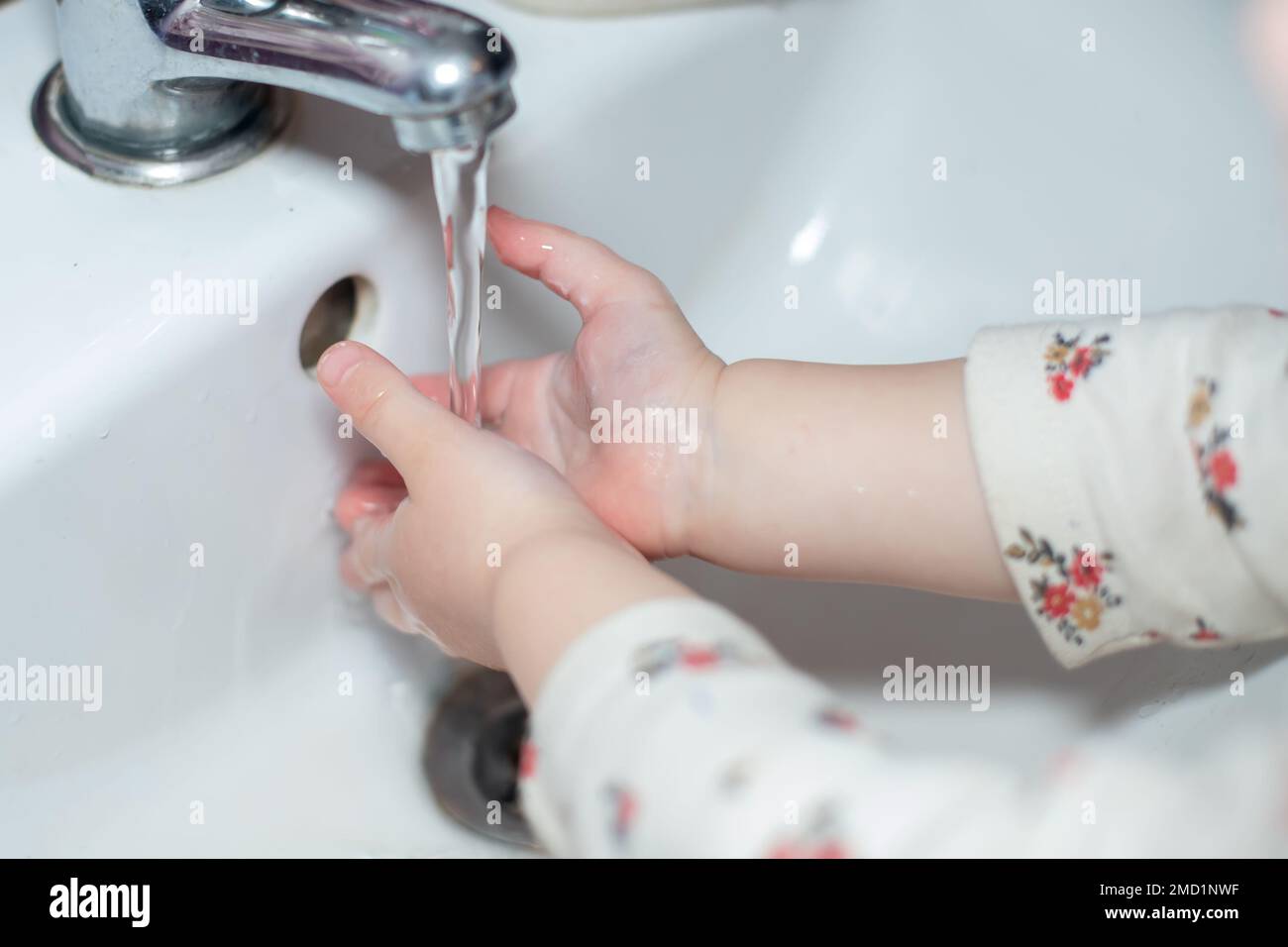 Kid washing hands in white basin. cleaning hand to stop spread of Covid-19, Coronavirus pandemic Stock Photo