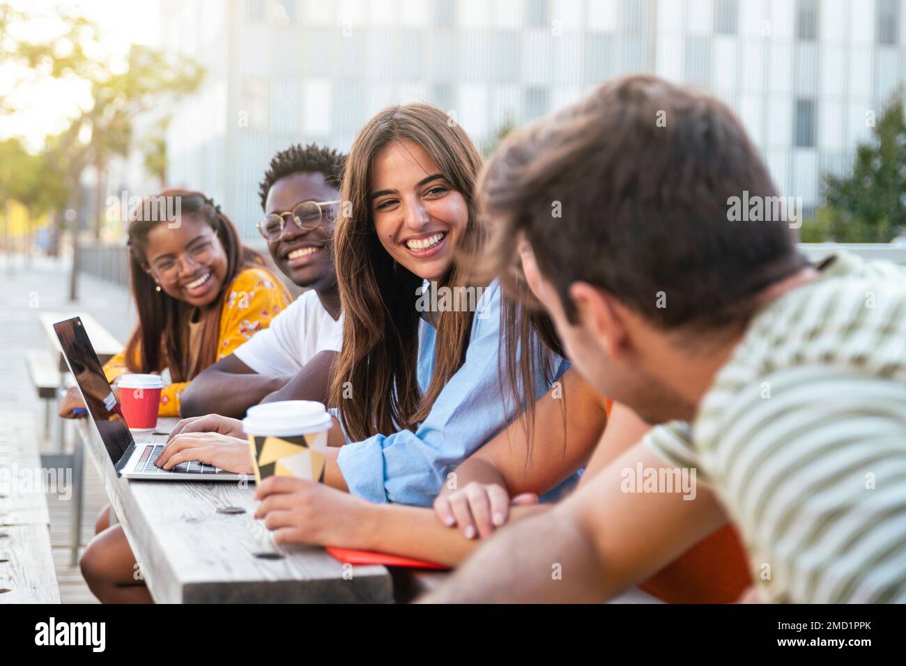 Group of five friends having fun together - students talking laughing and enjoying their time - focus on girl - education concept Stock Photo