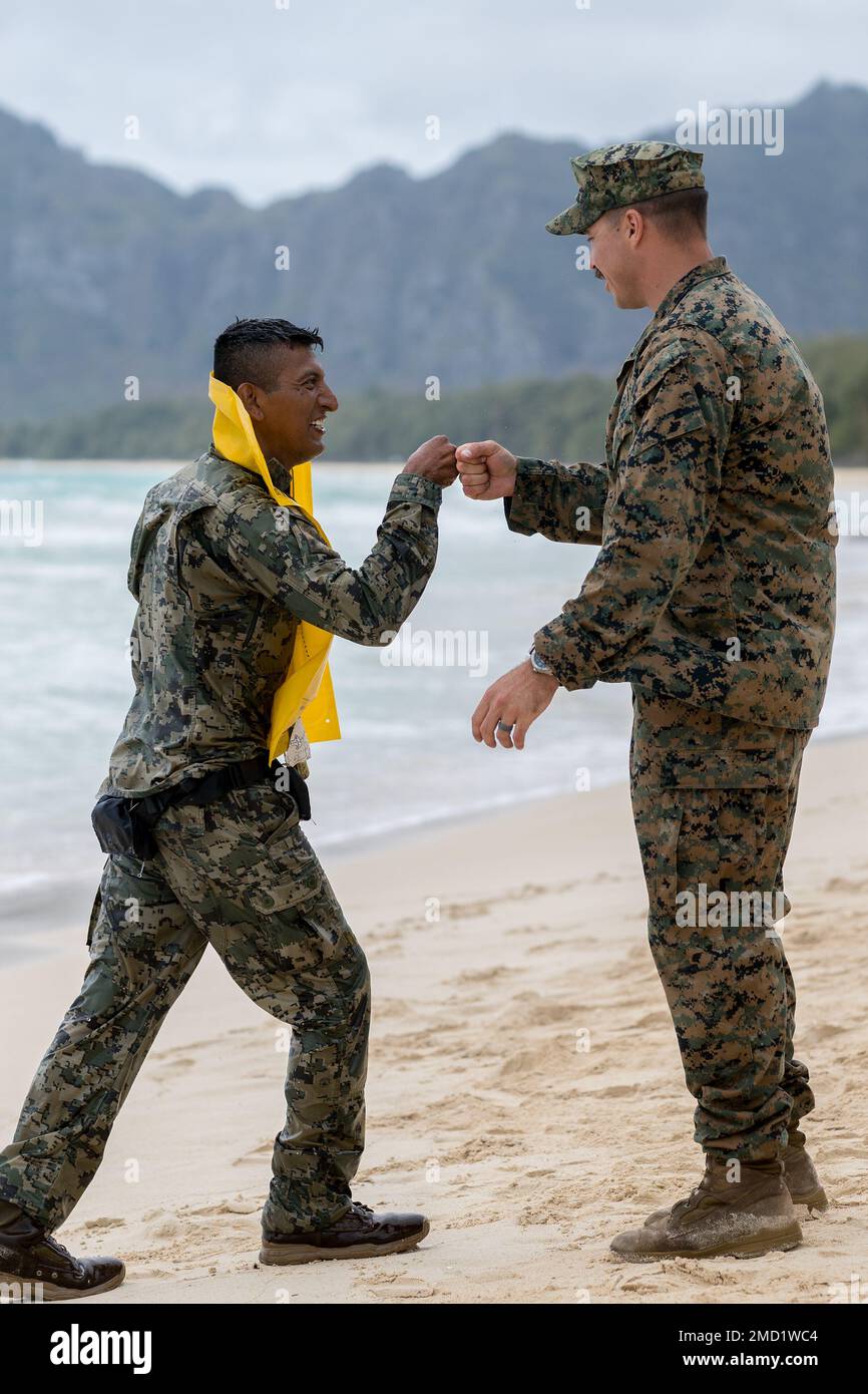 MARINE CORPS BASE HAWAII, Hawaii (July 12, 2022) — U.S. Marine Gunnery Sergeant John Beck, (right), congratulates a member of the Mexican Naval Infantry after completing a swimming exercise during amphibious operations training during Rim of the Pacific (RIMPAC) 2022, July 12. Twenty-six nations, 38 ships, four submarines, more than 170 aircraft and 25,000 personnel are participating in RIMPAC from June 29 to Aug. 4 in and around the Hawaiian Islands and Southern California. The world’s largest international maritime exercise, RIMPAC provides a unique training opportunity while fostering and s Stock Photo