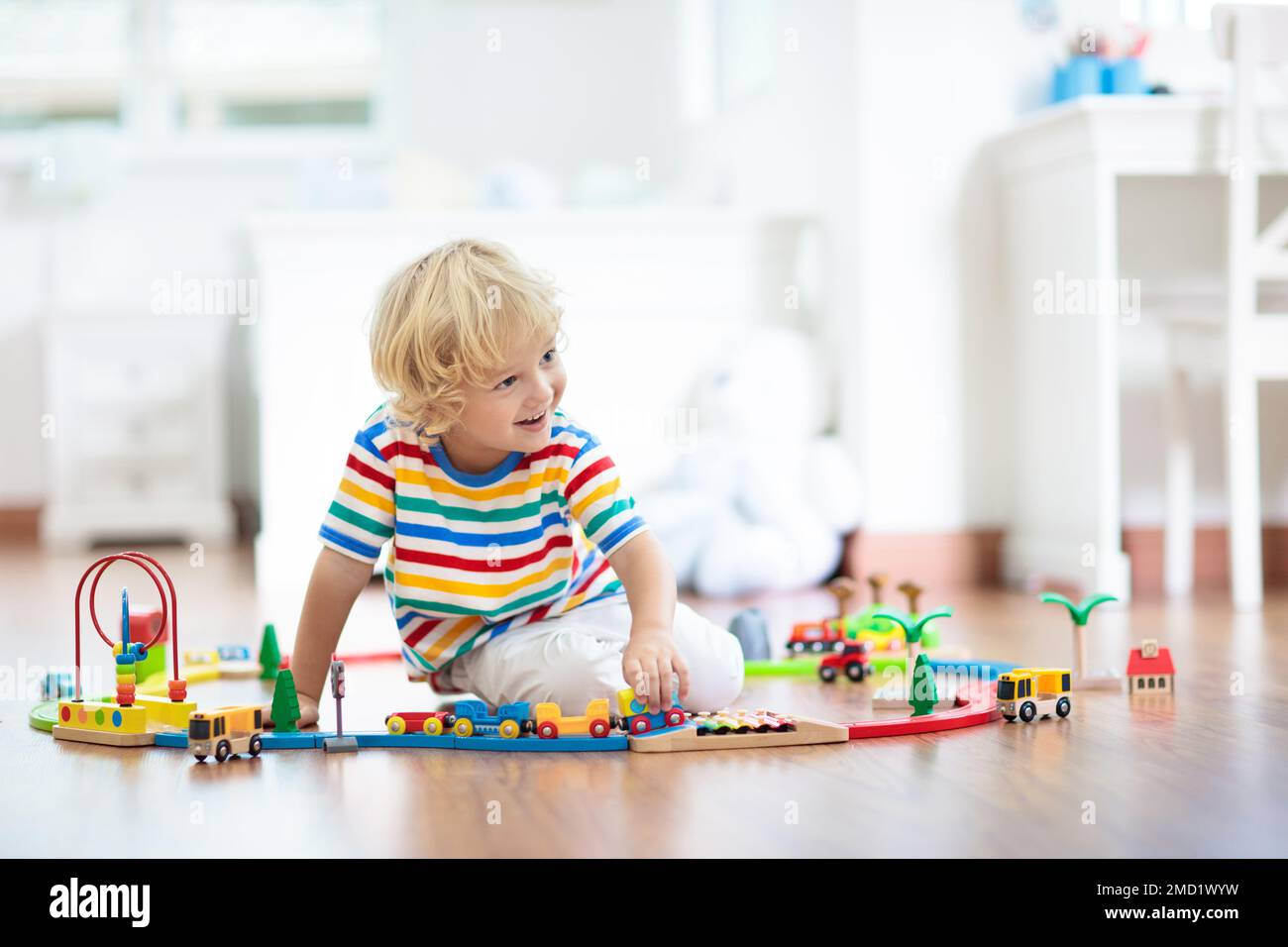 Kids play with wooden railway. Child with toy train. Educational toys