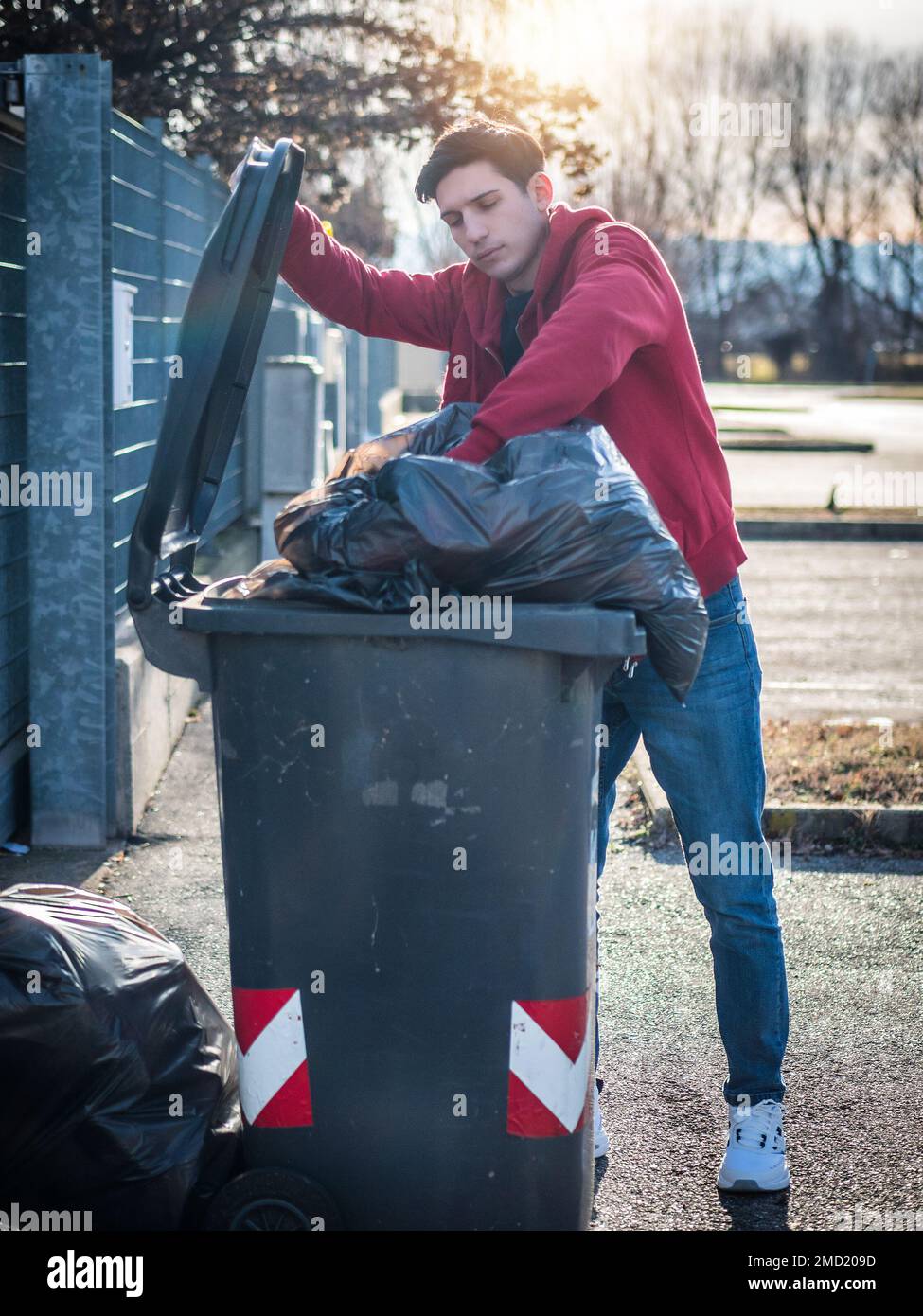 Attractive young man putting out rubbish standing Stock Photo
