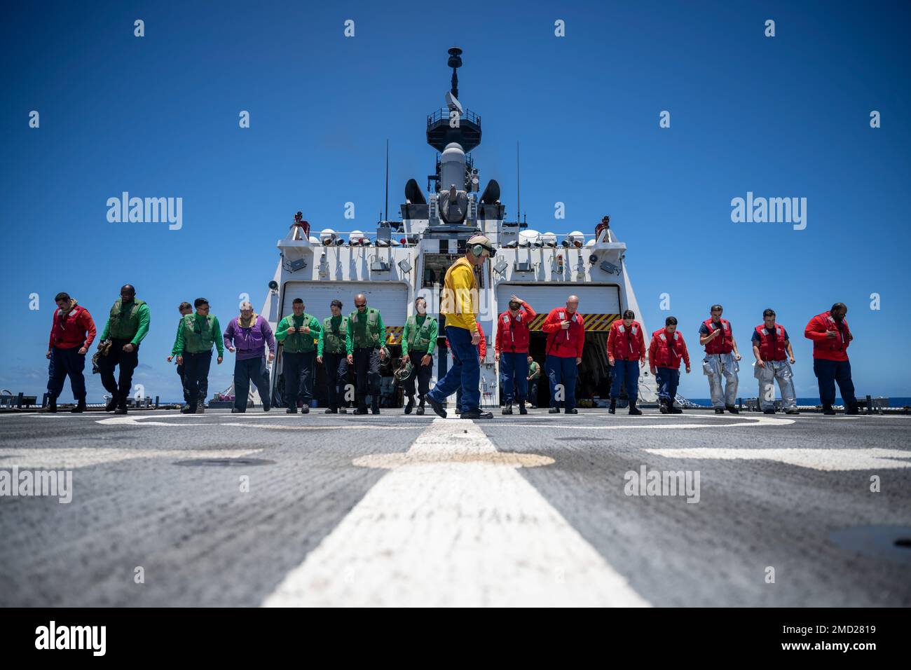 PACIFIC OCEAN (July 13, 2022) U.S. Coast Guard crew members aboard Legend-class cutter USCGC Midgett (WMSL 757) and U.S. Navy Sailors check the flight deck for debris prior to flight operations during Rim of the Pacific (RIMPAC) 2022. Twenty-six nations, 38 ships, four submarines, more than 170 aircraft and 25,000 personnel are participating in RIMPAC from June 29 to Aug. 4 in and around the Hawaiian Islands and Southern California. The worlds largest international maritime exercise, RIMPAC provides a unique training opportunity while fostering and sustaining cooperative relationships among pa Stock Photo