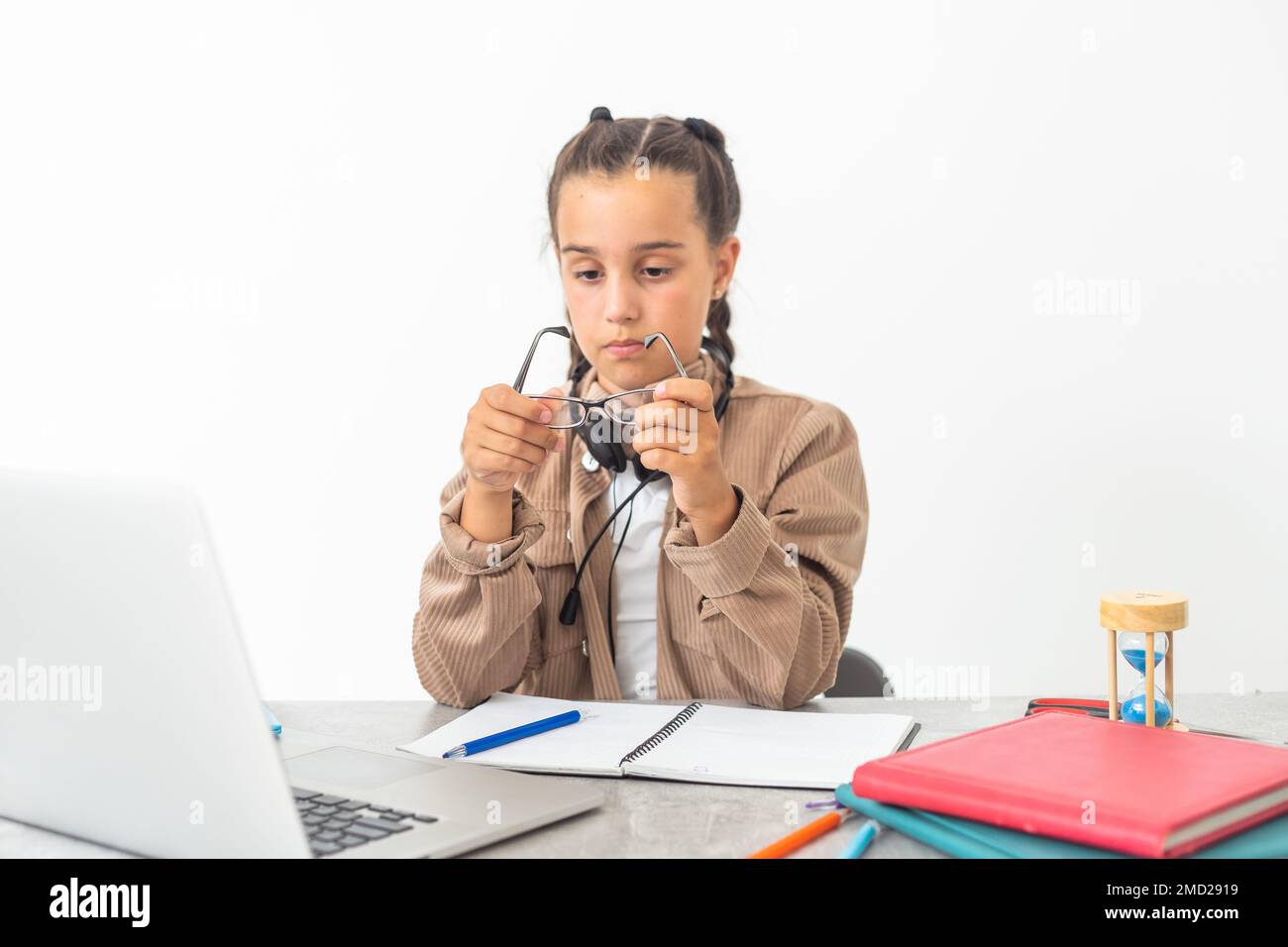 caucasian girl sitting at the desk and writing in a notebook and doing ...