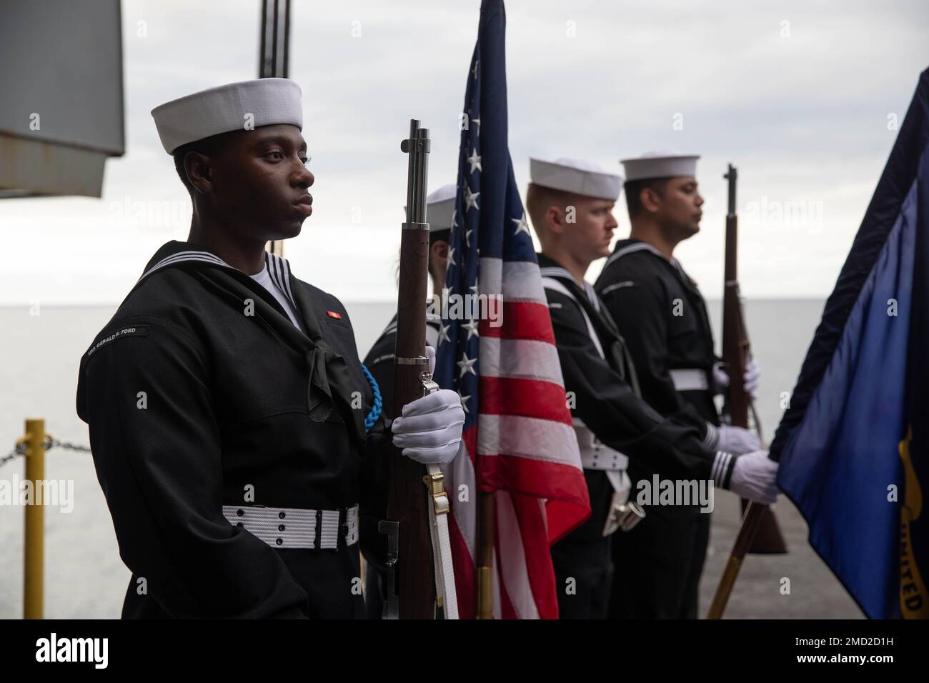 USS Gerald R. Ford's (CVN 78) color guard present colors and arms during a burial at sea ceremony on the ship’s aircraft elevator, July 12, 2022. The remains of 30 service and family members were committed to the sea. Ford is underway in the Atlantic Ocean conducting an independent steaming operation. Stock Photo