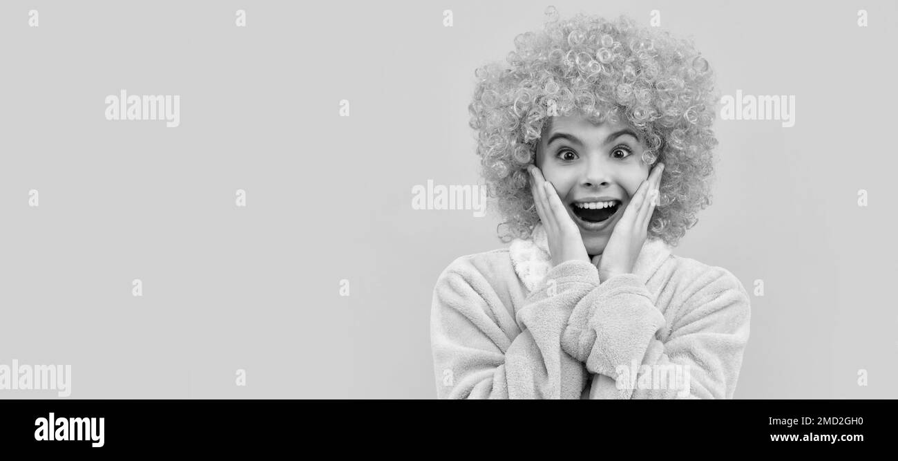 childhood happiness. birthday or pajama party. funny kid in curly clown wig. Funny teenager child on party, poster banner header with copy space. Stock Photo