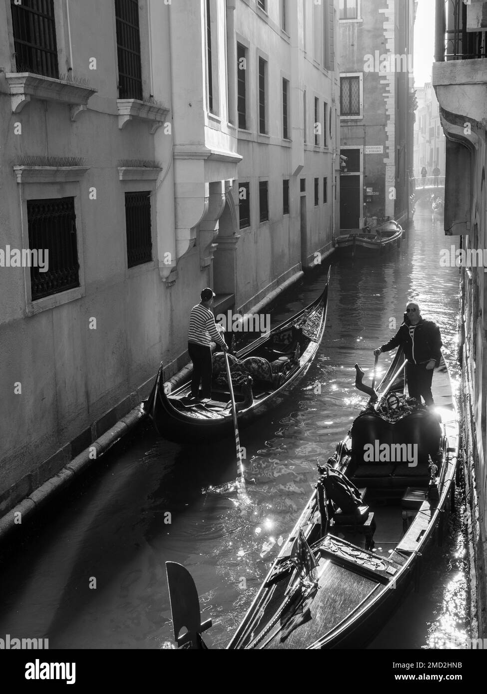 October 31, 2022 - Venice, Italy: Black and white photo of two gondolas riding along the canal of Venice. Tourism concept. Stock Photo