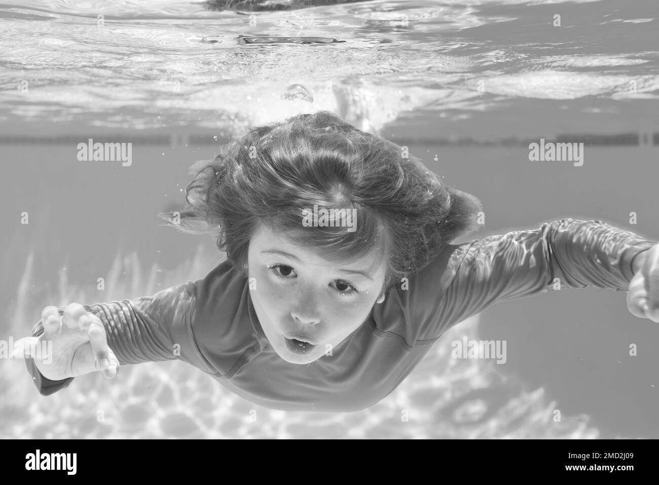 Boy swim and dive underwater. Under water portrait in swim pool. Child