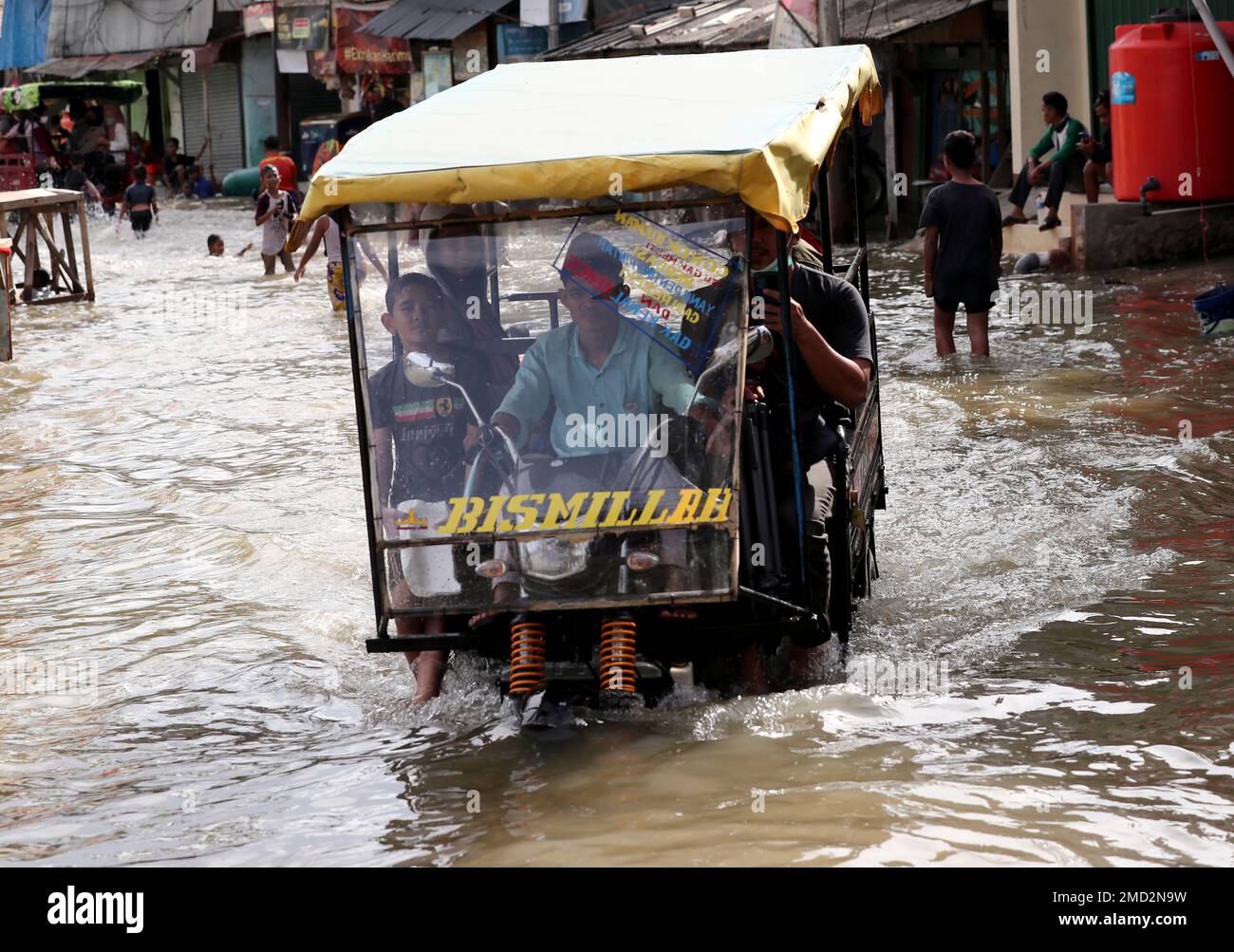 People ride on a threewheeled taxi during a tidal flood in Jakarta, Indonesia, Tuesday, Nov. 9