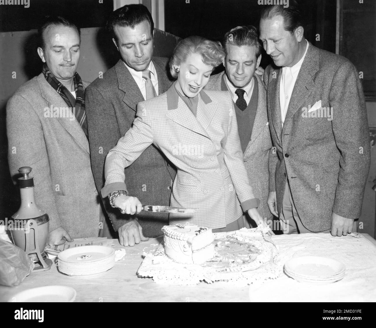 DICK POWELL and SIGNE HASSO celebrating with Movie Crew members on set candid during filming of TO THE ENDS OF THE EARTH / ASSIGNED TO TREASURY (working title) 1948 director ROBERT STEVENSON original story / screenplay Jay Richard Kennedy costume design Jean Louis producer Sidney Buchman Kennedy-Buchman Pictures for Columbia Pictures Stock Photo