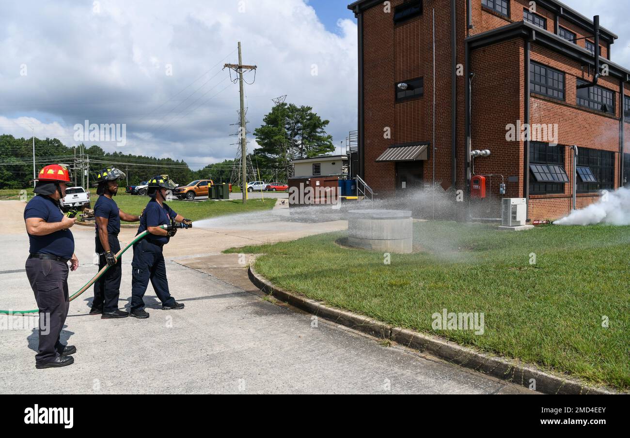 During an exercise led by Arnold Engineering Development Complex’s Inspector General’s Office and the Commander’s Wing Inspection Team, Fire and Emergency Services personnel Chevis Lee, center, a firefighter, and Ken Young, right, a paramedic/firefighter, spray water to indicate they are battling a fire and speeding the dissipation of a chemical plume released as a result of an simulated explosion, July 12, 2022, at Arnold Air Force Base, Tennessee. The exercise simulated a terrorist attack on the base to test the response by various organizations on base. The smoke seen in the photo was a spe Stock Photo