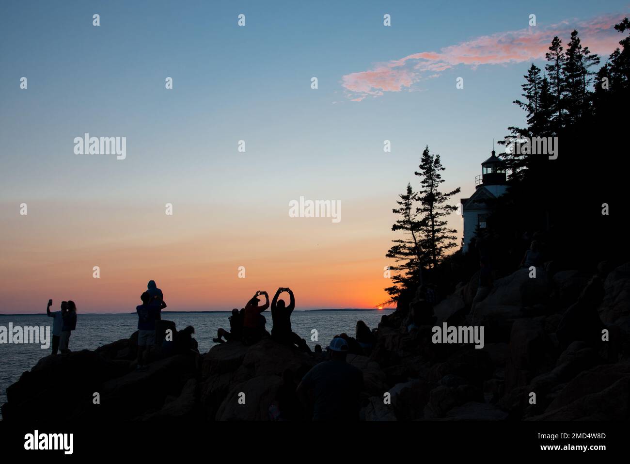 Tourists take in the last rays of sunset at Bass Harbor Lighthouse in Acadia National Park, Mount Desert Island, Maine, USA Stock Photo