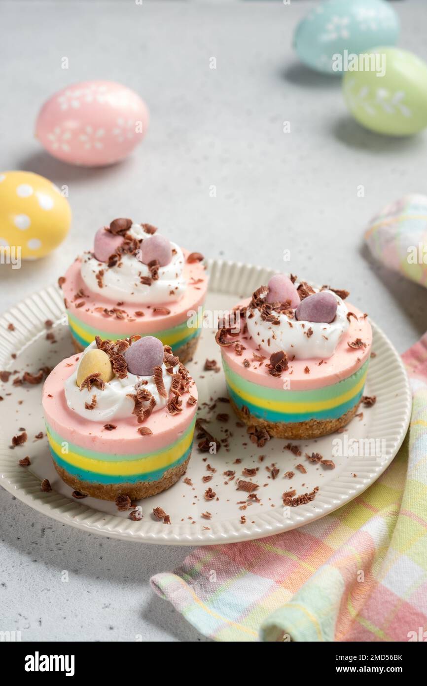 Easter mini cheesecakes with candy eggs and whipped cream Stock Photo