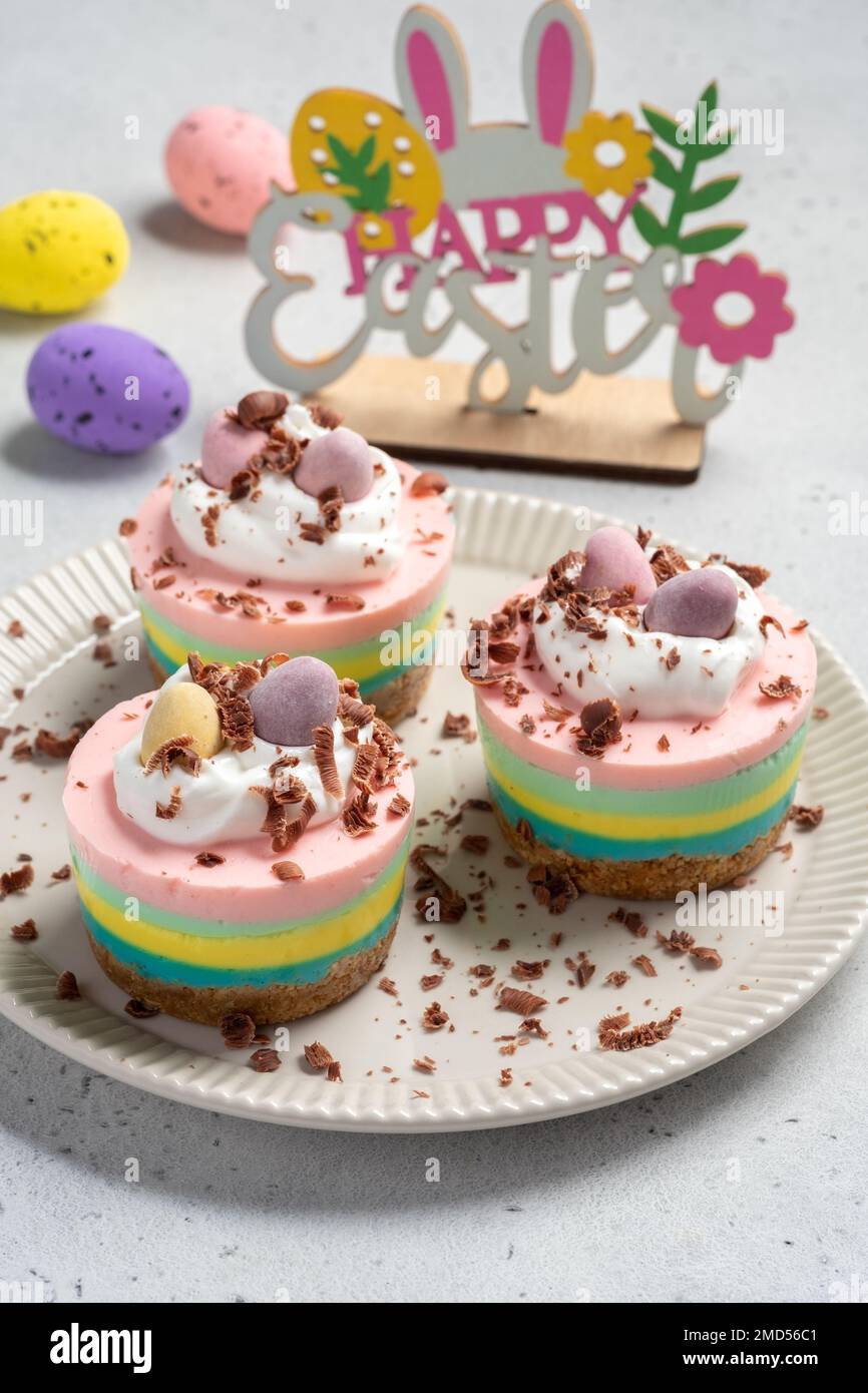 Easter mini cheesecakes with candy eggs and whipped cream Stock Photo