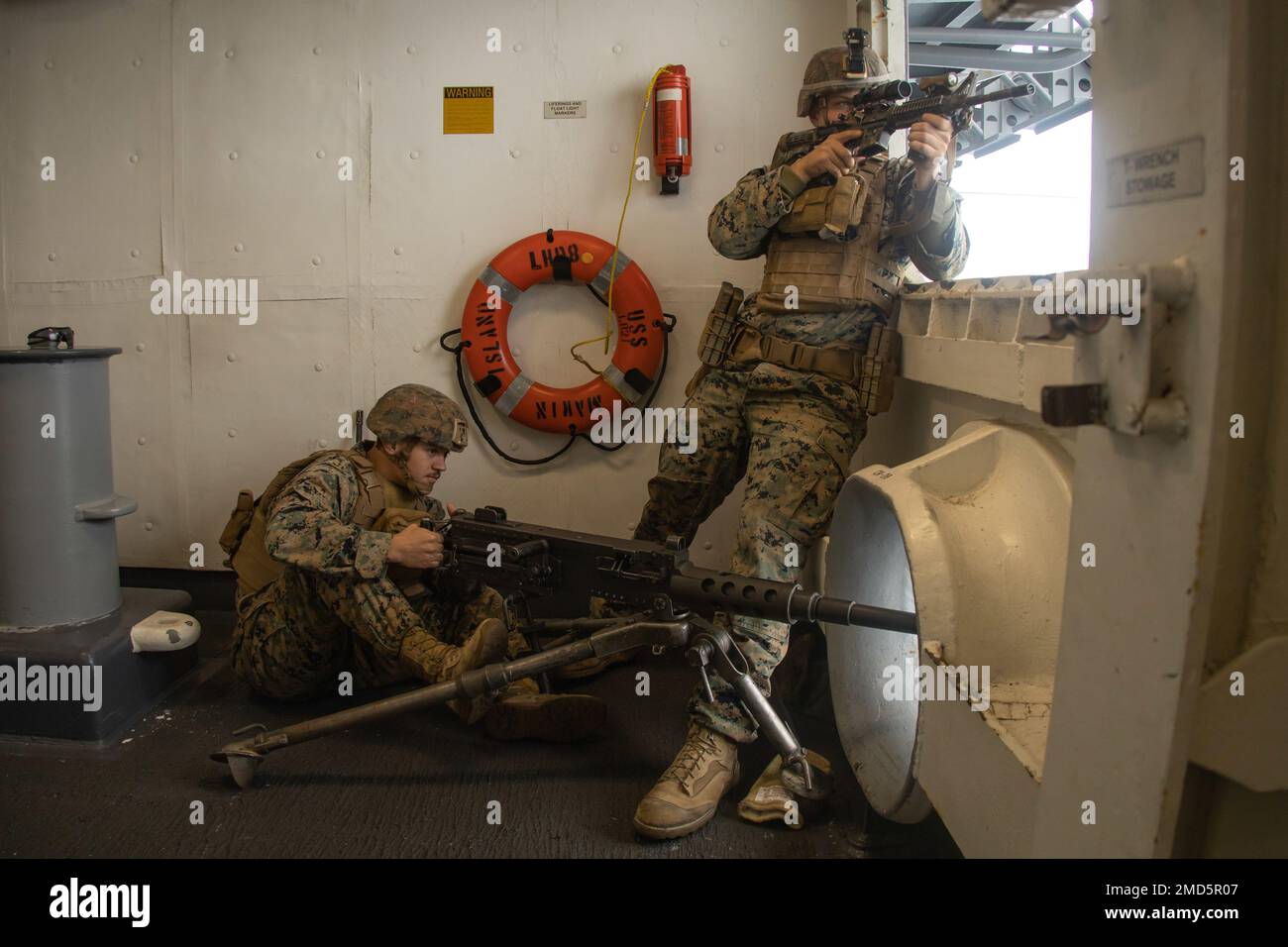 PACIFIC OCEAN (July 13, 2022) – U.S. Marine Corps Cpl. Brice Bailey, left, a machine gunner and Cpl. Jacob Tetzloff, an anti-tank missile gunner, both with Battalion Landing Team 2/4, 13th Marine Expeditionary Unit, spot a simulated enemy ship during a Defense of the Amphibious Task Force exercise aboard amphibious assault ship USS Makin Island (LHD 8), July 13. The 13th MEU is currently embarked aboard the USS Makin Island conducting routine operations in the U.S. 3rd Fleet. Stock Photo