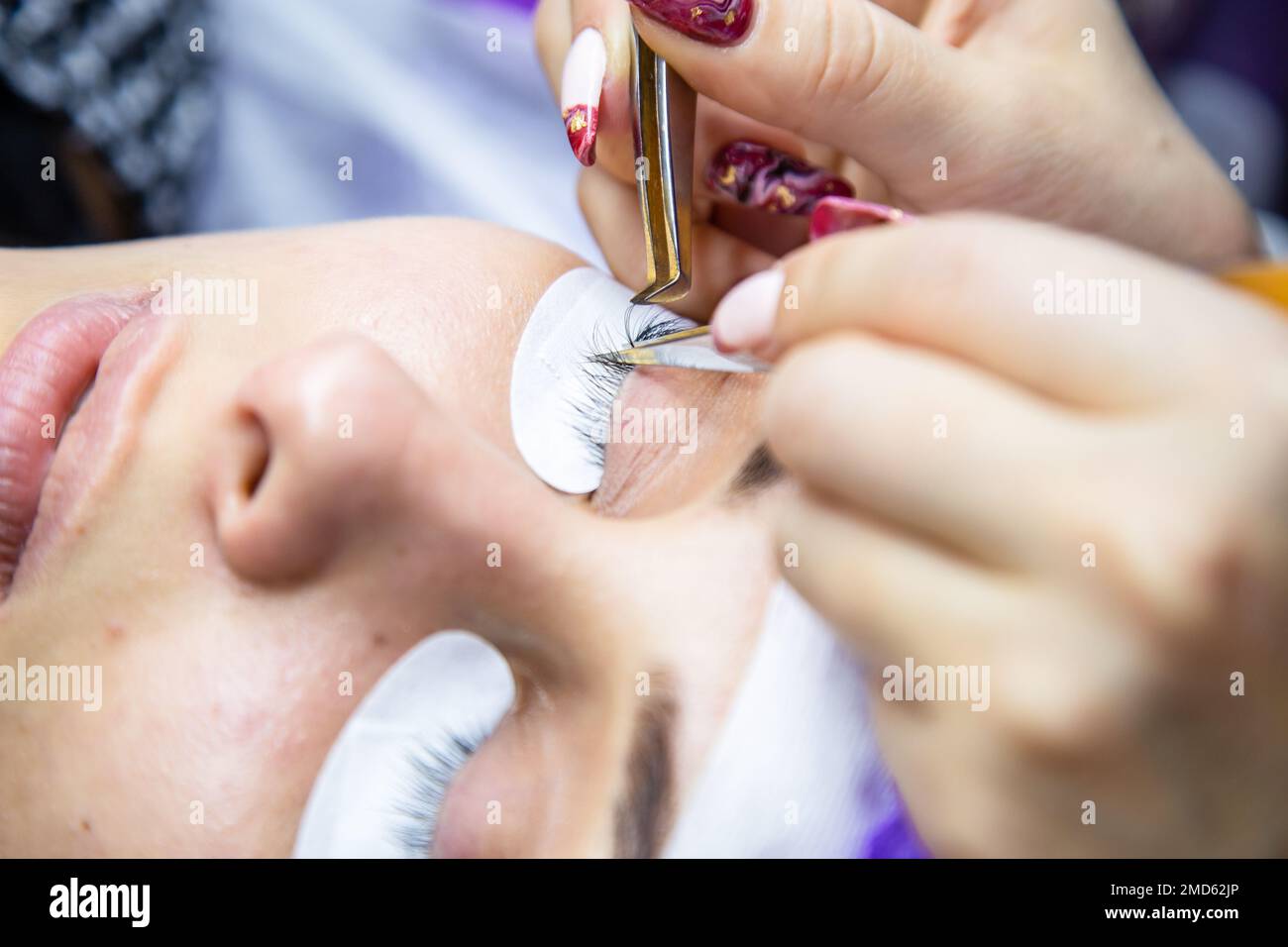 woman at spa salon applying false eyelashes Stock Photo