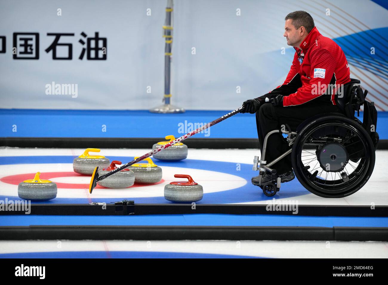 Mark Ideson of Canada helps his team line up a throw during their semifinal match against the United States at the World Wheelchair Curling Championship, a test event for the 2022 Winter