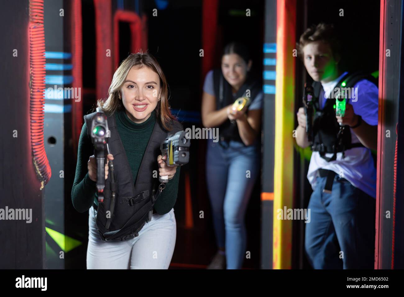 Young lady having fun playing lasertag in arena Stock Photo