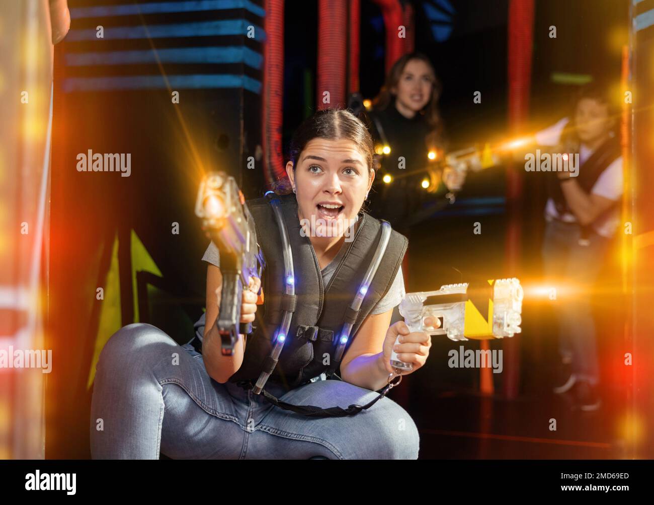Girl running and dodging while playing lasertag Stock Photo