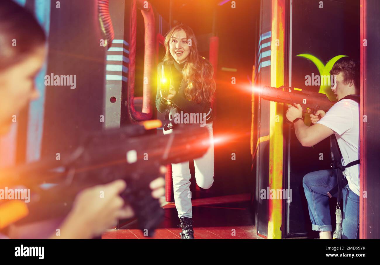 Girl running and dodging while playing lasertag Stock Photo