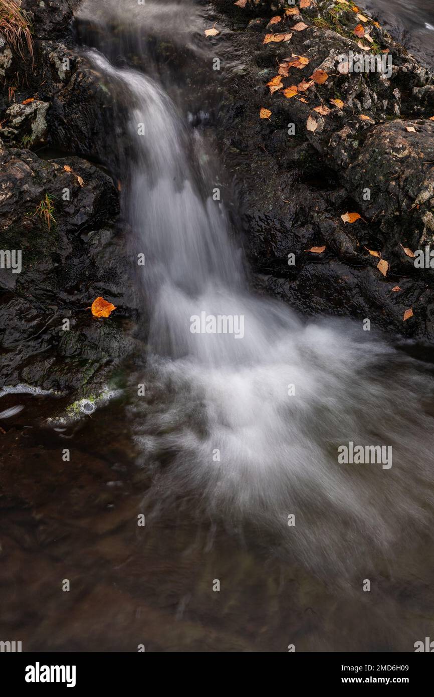 Small waterfall with colouful autumnal leaves Stock Photo