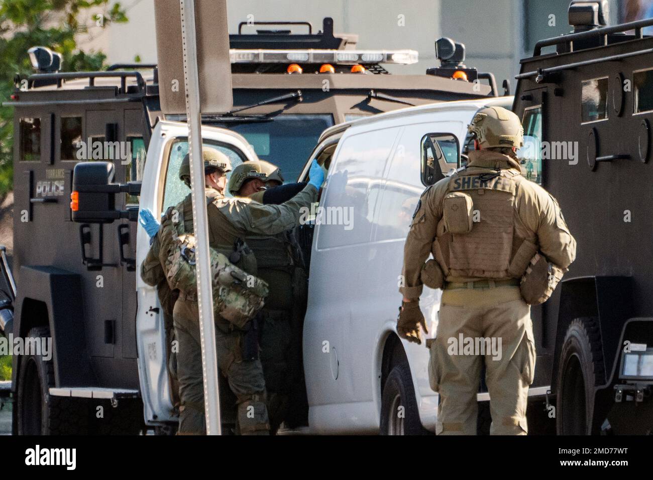 Members of a SWAT team enter a van and look through its contents in ...