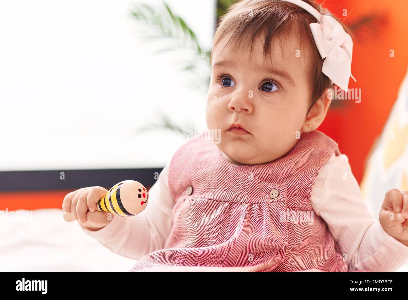 Adorable hispanic baby playing maraca sitting on bed at bedroom Stock ...