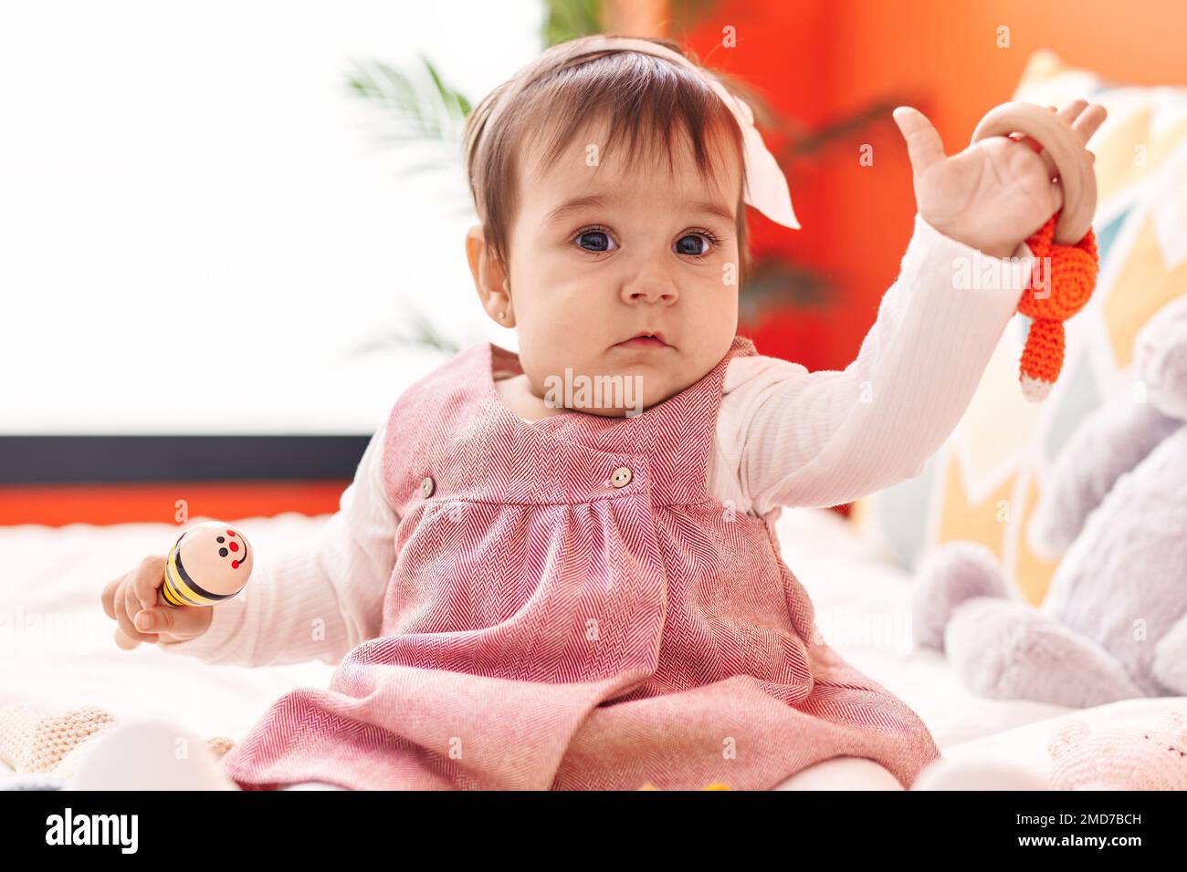 Adorable hispanic baby playing maraca sitting on bed at bedroom Stock ...