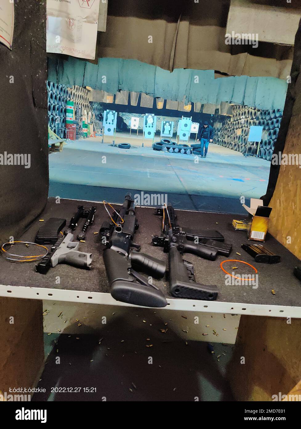 A variety of guns on the desk with the targets in the background Stock