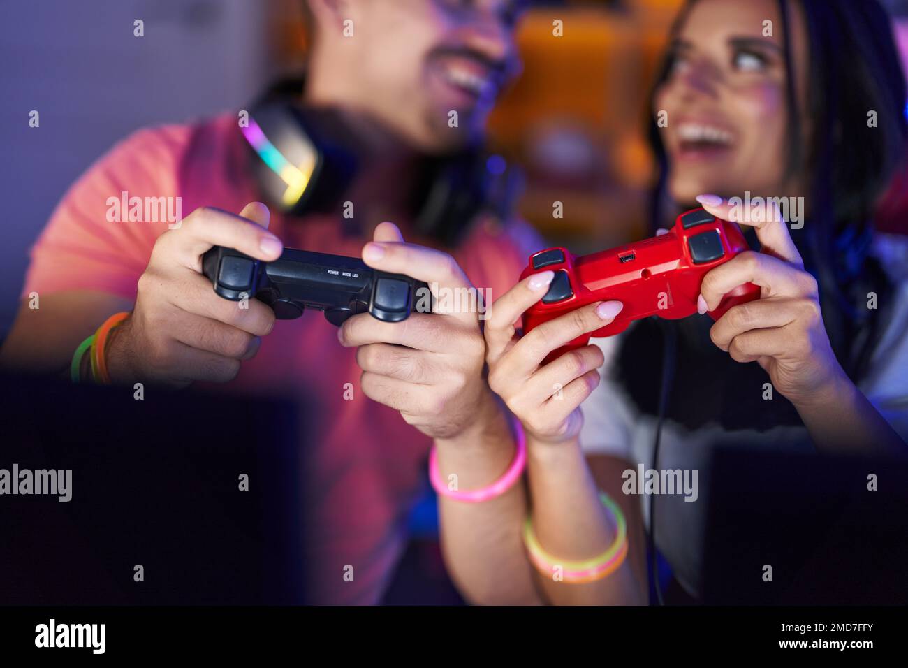 Man and woman streamers playing video game using computer and joystick ...
