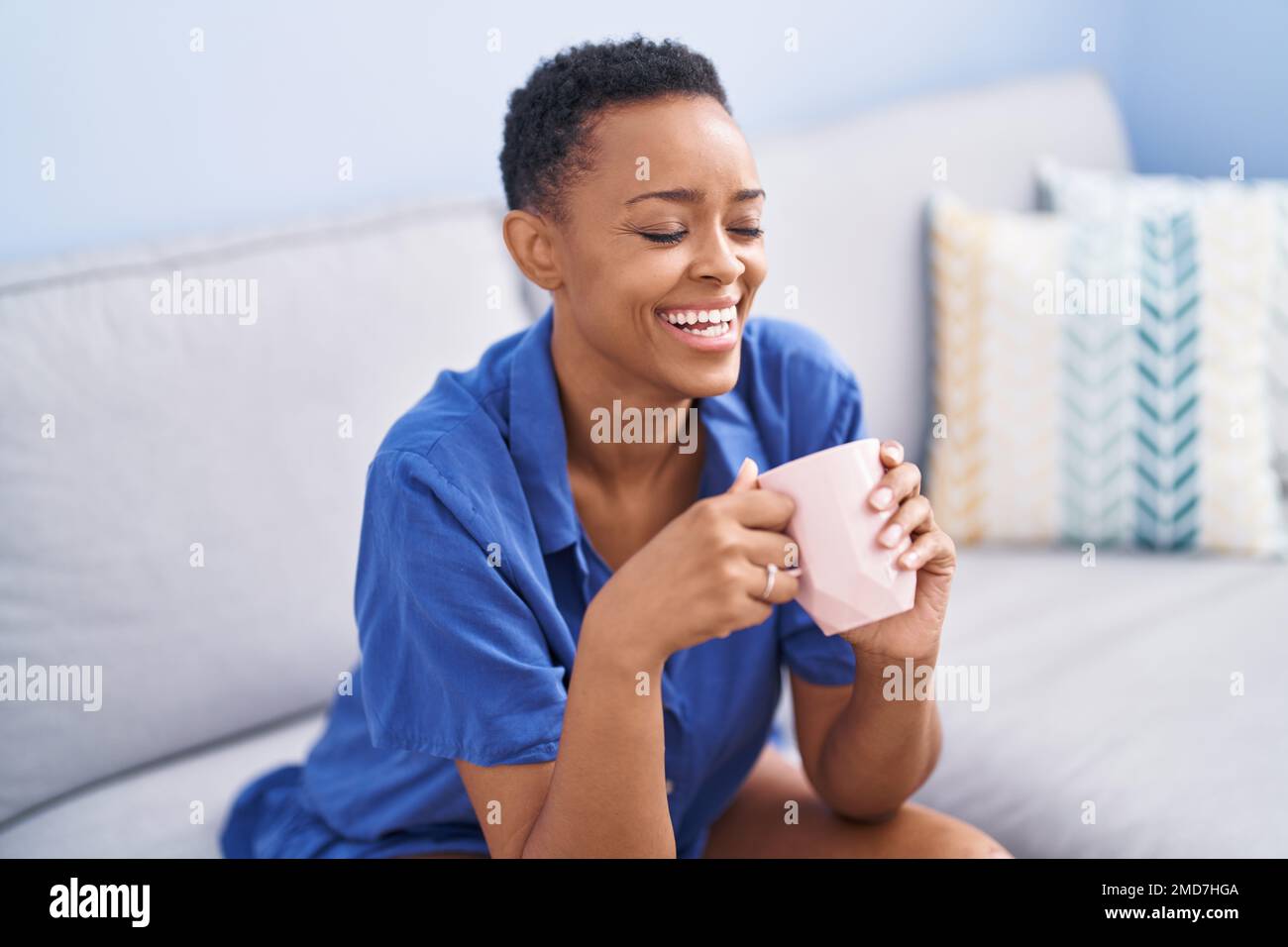 African american woman drinking coffee sitting on sofa at home Stock ...