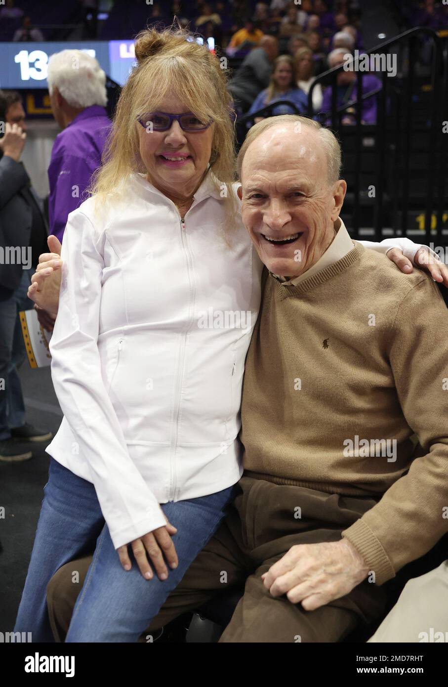 Jackie Maravich (Pete Maravich's widow) sits on the lap of former