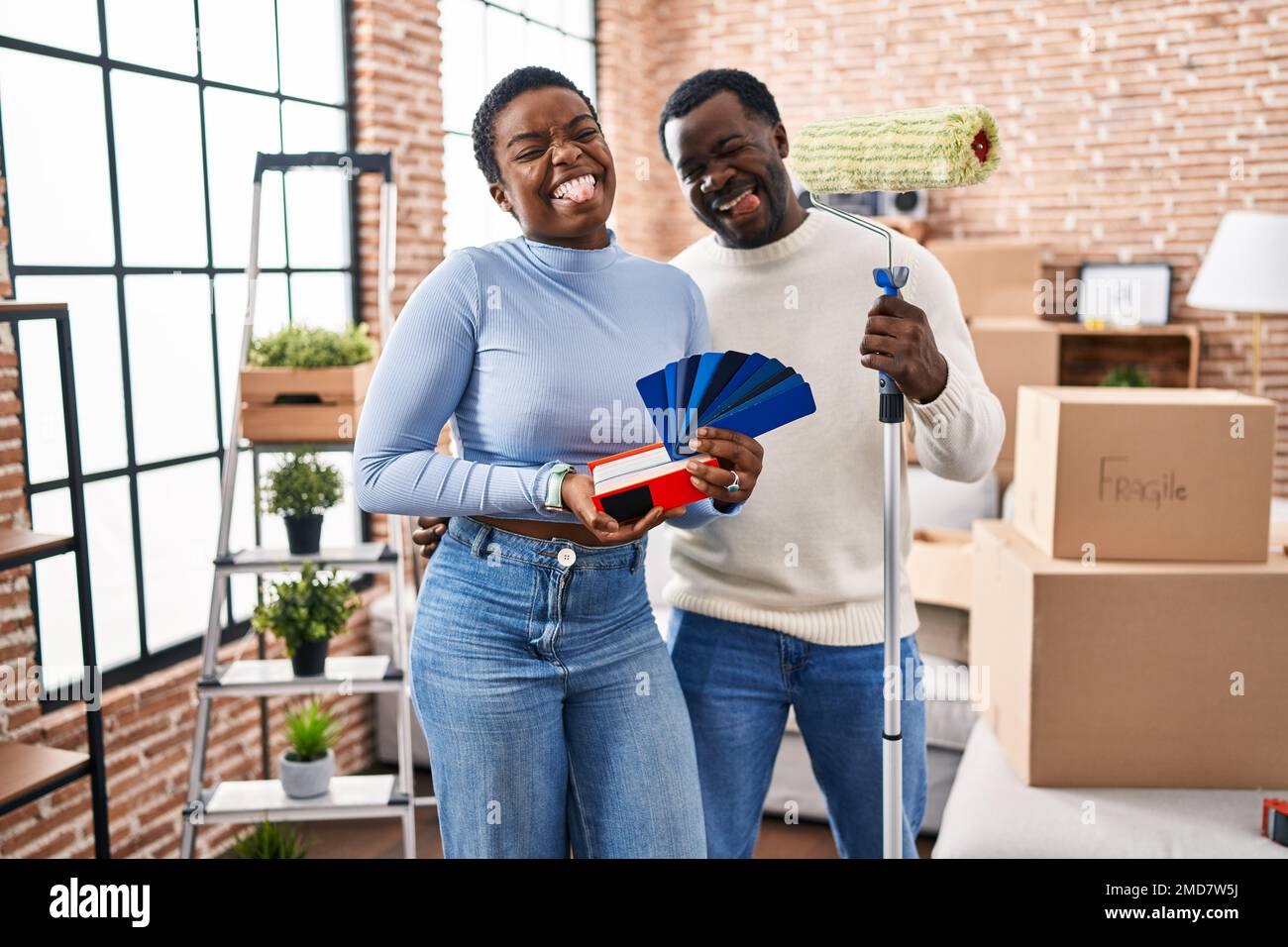 Young african american couple moving to a new home choosing walls color ...