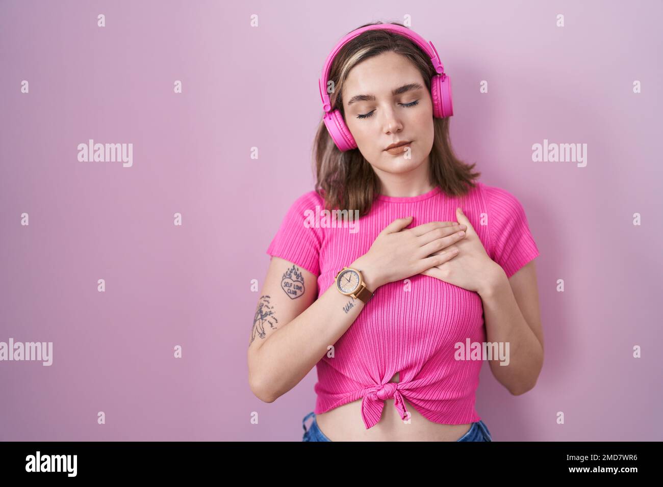 Blonde caucasian woman listening to music using headphones smiling with ...