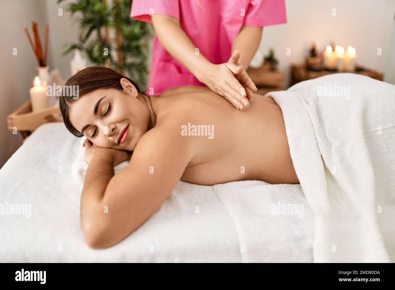 https://c8.alamy.com/comp/2MD80DA/young-beautiful-hispanic-woman-lying-on-table-having-back-massage-at-beauty-salon-2MD80DA.jpg