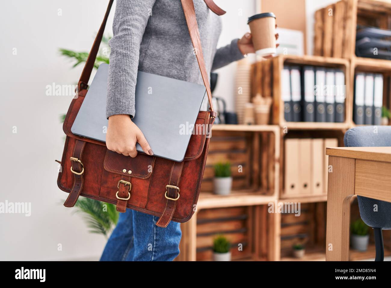 Young middle east woman business worker holding briefcase drinking