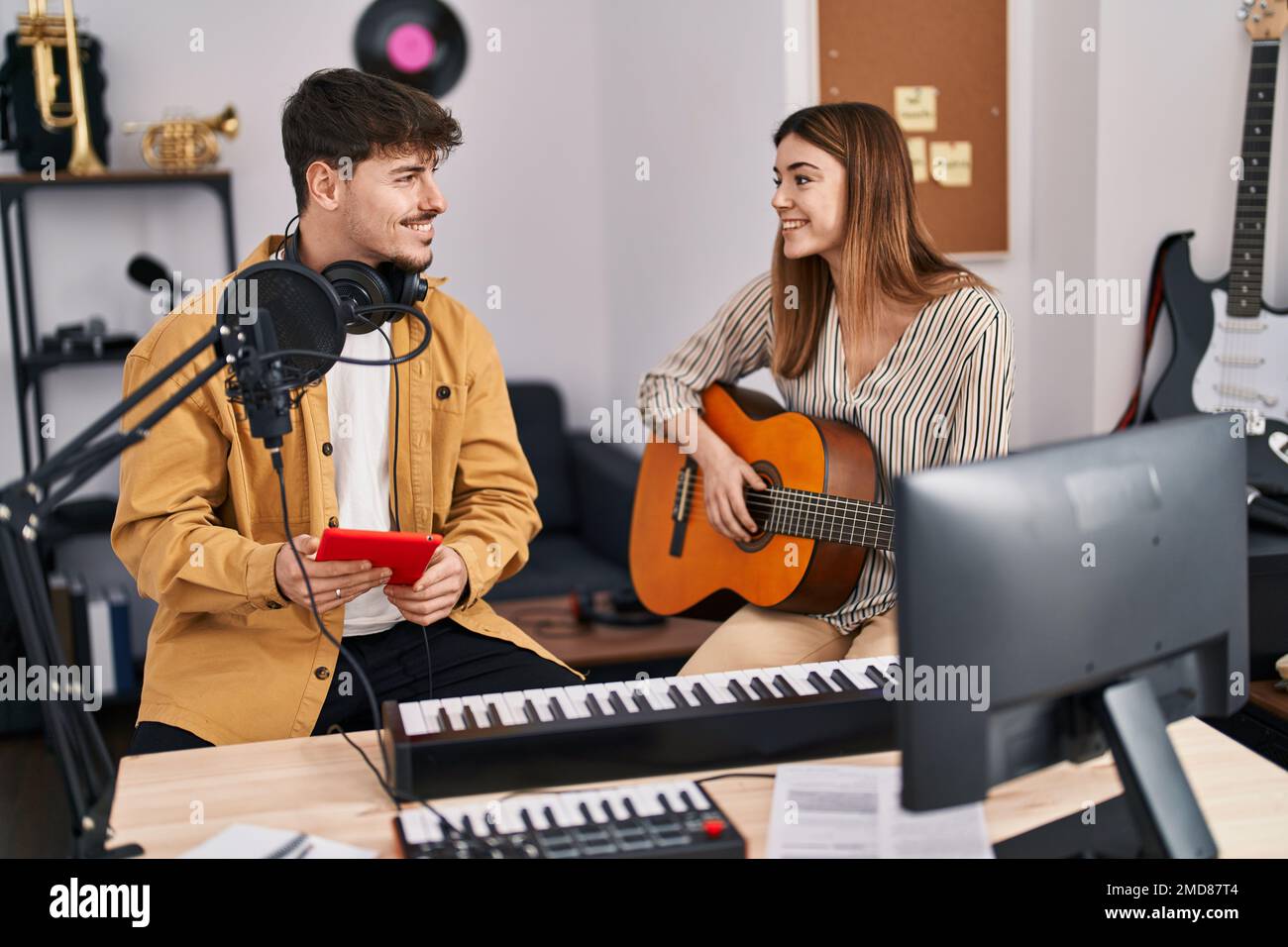Mand and woman musicians playing classical guitar using touchpad at music studio Stock Photo Alamy