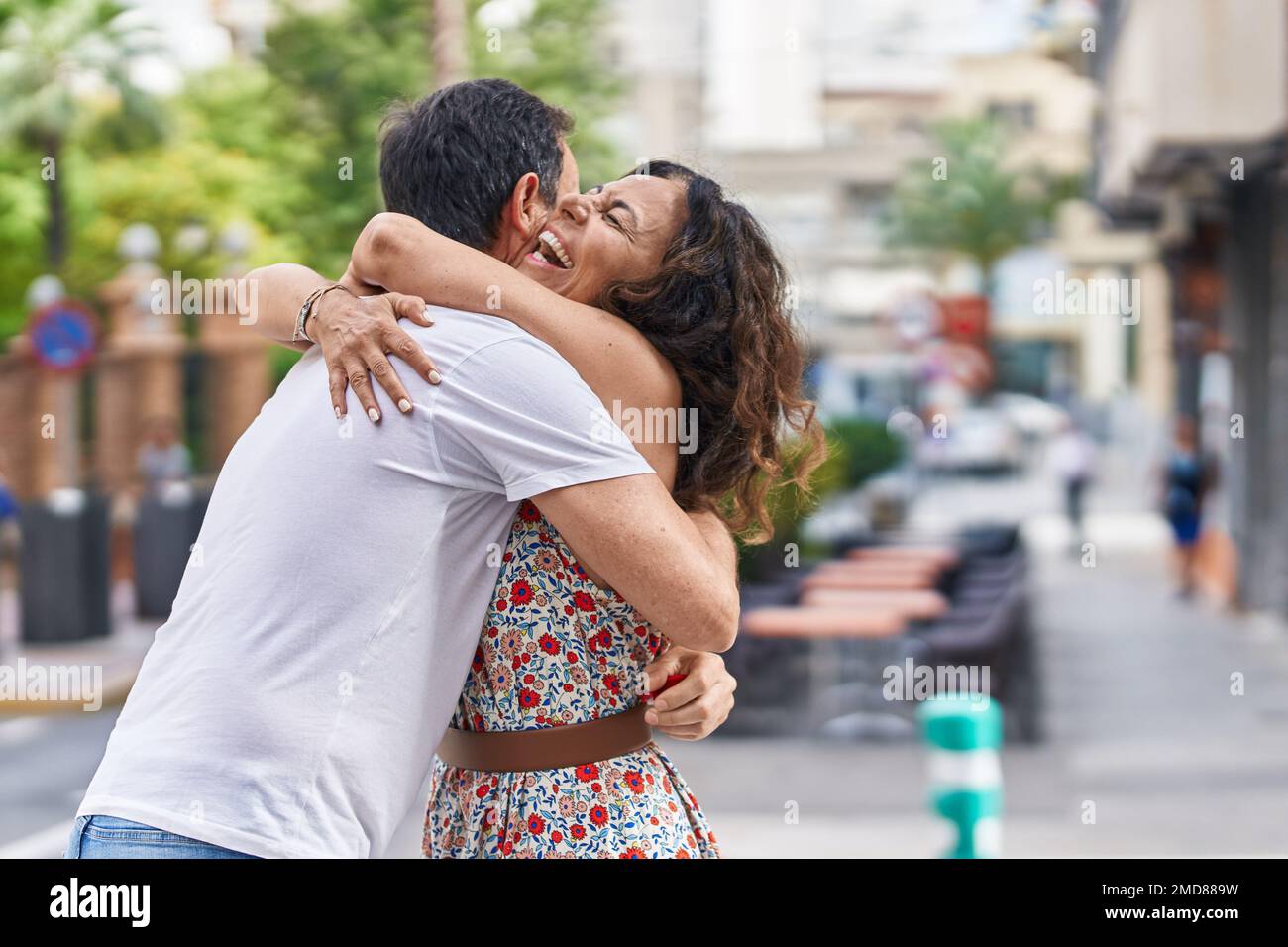 Man and woman couple hugging each other at street Stock Photo - Alamy
