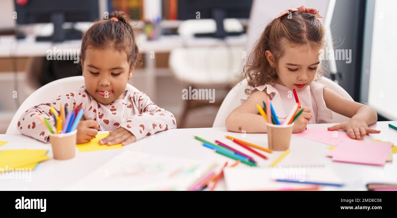 Two kids preschool students sitting on table drawing on paper at ...