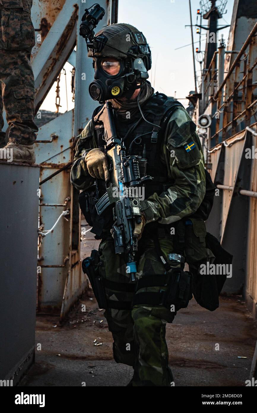 A Swedish Marine with 4th Marine Regiment, Swedish Amphibious Corps provides security for visit, board, search, and seizure during exercise TYR 22 at the NATO Maritime Interdiction Operational Training Centre (NMIOTC) in Souda bay, Greece, July 14, 2022. TYR 22 is a maritime interdiction operations exercise held at NMIOTC, bringing together Swedish Marines, U.S. Marines, U.S. Navy Special warfare combatant-craft crewmen to improve US and NATO Partner operational capacity, capability, and interoperability. Stock Photo