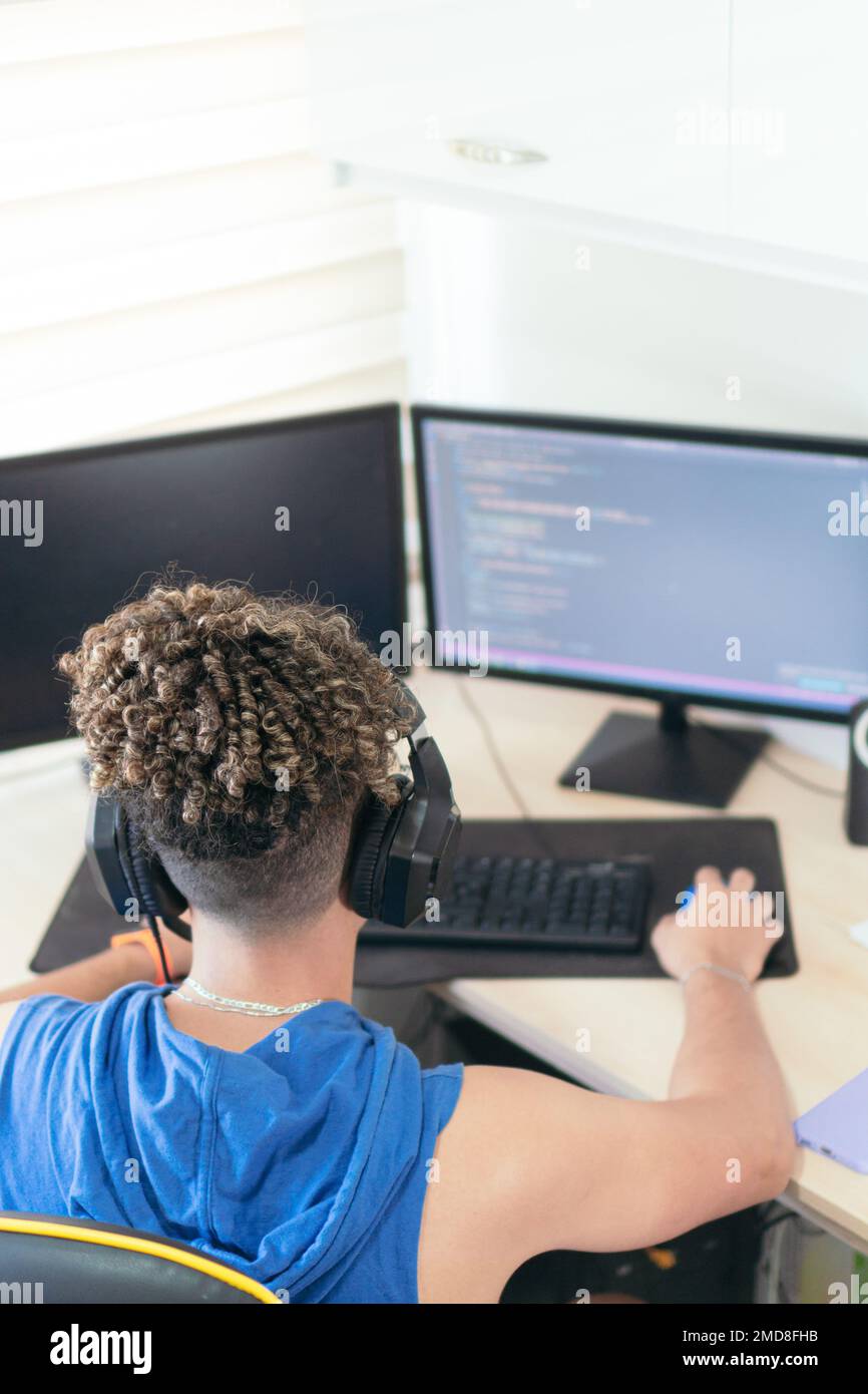 From above, software engineer sitting at desk and typing on computer keyboard while creating code during work at home. Stock Photo