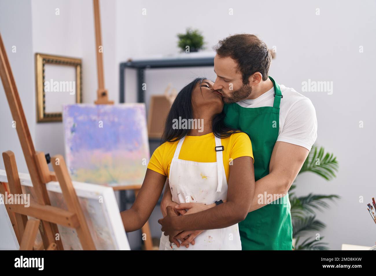 Man and woman artist couple hugging each other drawing at art studio ...